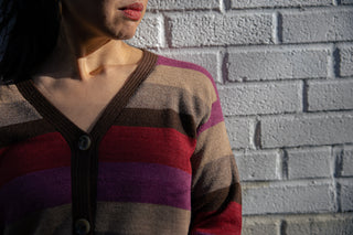 Atardecer Alpaca Cardigan — striped alpaca knit in earthy brown, taupe, crimson, and violet, inspired by Andean sunsets.